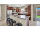 The kitchen features dark wood cabinetry, stainless steel appliances, and a granite island with seating at 6869 Desert Thrasher Dr, North Las Vegas, NV 89084