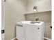 Bright laundry area with modern white washer and dryer and decor on shelf at 6869 Desert Thrasher Dr, North Las Vegas, NV 89084