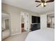 Spacious main bedroom with a large television, ceiling fan, and adjacent bathroom at 6869 Desert Thrasher Dr, North Las Vegas, NV 89084