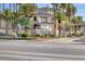 Beautiful condo exterior with mature landscaping, palm trees and signage at the entry to the community at 7155 S Durango Dr # 309, Las Vegas, NV 89113