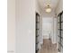 The hallway has a light fixture, gray walls, light wood floors, and black sliding doors at 7155 S Durango Dr # 309, Las Vegas, NV 89113