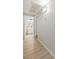 Hallway with light walls and flooring leads to a bathroom featuring modern vanity and decorative shelves at 7155 S Durango Dr # 309, Las Vegas, NV 89113