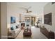 Bright living room featuring a fireplace, modern ceiling fan, and a dining area near the sliding glass doors at 7155 S Durango Dr # 309, Las Vegas, NV 89113