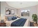 Cozy main bedroom with neutral decor, a large window, and modern furnishings, staged with stylish decor at 7155 S Durango Dr # 309, Las Vegas, NV 89113