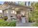 Outdoor community picnic area, shaded by a pergola, featuring a grill and table at 7155 S Durango Dr # 309, Las Vegas, NV 89113