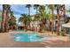 Community pool with mature palm trees and buildings in the background at 7155 S Durango Dr # 309, Las Vegas, NV 89113
