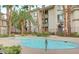 Community pool surrounded by mature palm trees and buildings at 7155 S Durango Dr # 309, Las Vegas, NV 89113