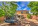 Spacious backyard with mature trees, trampoline, and space for outdoor enjoyment at 75 Archer Glen Ave, Henderson, NV 89002
