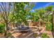 Landscaped backyard with mature trees, brick accents, and a trampoline at 75 Archer Glen Ave, Henderson, NV 89002