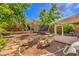 Beautiful backyard featuring mature trees, a trampoline, patio furniture, and landscaping at 75 Archer Glen Ave, Henderson, NV 89002