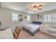Cozy bedroom with a ceiling fan, plantation shutters, and a comfortable bed with a couch at 75 Archer Glen Ave, Henderson, NV 89002