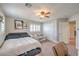 Bright bedroom featuring a ceiling fan, plantation shutters, and a comfortable bed with a couch at 75 Archer Glen Ave, Henderson, NV 89002