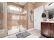 Bathroom featuring a shower, a sink with a mirror, a toilet and tile flooring at 7630 Canyon Diablo Rd, Las Vegas, NV 89179
