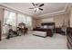 Spacious bedroom featuring a bed, windows, a ceiling fan and carpeted floor at 7630 Canyon Diablo Rd, Las Vegas, NV 89179