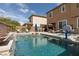 Inviting pool area featuring a waterfall feature, a basketball hoop, and comfortable lounge chairs, perfect for summer fun at 7630 Canyon Diablo Rd, Las Vegas, NV 89179