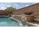 Inviting pool area with waterfall feature and lush landscaping, perfect for creating a relaxing outdoor oasis at 7630 Canyon Diablo Rd, Las Vegas, NV 89179