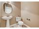 Neutral-toned powder room with pedestal sink, round mirror, and tile flooring at 7637 Good Fortune Ct, Las Vegas, NV 89139