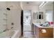 Well-lit bathroom with a tub, shower, vanity, and natural light from an adjoining room at 7645 Interlace St, Las Vegas, NV 89149