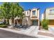 Two-story home featuring a covered porch, attached garage, and mature landscaping at 7645 Interlace St, Las Vegas, NV 89149