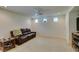 Bright living room with neutral carpet, recessed lights, a ceiling fan and a brown leather sofa at 7645 Interlace St, Las Vegas, NV 89149
