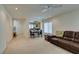 Open-concept living room adjacent to the kitchen featuring neutral carpet and bright natural light at 7645 Interlace St, Las Vegas, NV 89149