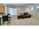 Spacious living room with carpet, a brown leather couch, and ceiling fan at 7645 Interlace St, Las Vegas, NV 89149