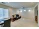 Bright living room with neutral carpet, ceiling fan, and a large window at 7645 Interlace St, Las Vegas, NV 89149