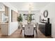 Well-lit dining room featuring a modern chandelier, sleek black buffet, and a large window with garden views at 7825 Desert Bell Ave, Las Vegas, NV 89128