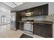 A kitchen featuring stainless steel appliances, dark cabinetry, and tile flooring at 823 Schooner Dr, Henderson, NV 89015