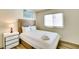 Well-lit bedroom with queen bed, crisp white linens, side table and sleek wood-look flooring at 864 E Eldorado Ln, Las Vegas, NV 89123