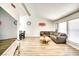 Bright living room with vaulted ceiling, wood floors, a large sectional sofa, modern art, and large windows at 864 E Eldorado Ln, Las Vegas, NV 89123