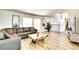 Bright living room with wood floors, a large sectional sofa, modern art, staircase, and a tv stand at 864 E Eldorado Ln, Las Vegas, NV 89123