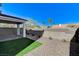 A cozy backyard featuring a small grass patch, gravel, and a covered patio for outdoor relaxation at 8786 Sand Verbena Ave, Las Vegas, NV 89117