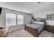Spacious bedroom featuring carpeted floors, two windows and a bed with patterned bedding at 8786 Sand Verbena Ave, Las Vegas, NV 89117
