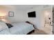 Comfortable bedroom leading to bathroom with carpeted floors, neutral color palette, and a bed with patterned bedding at 8786 Sand Verbena Ave, Las Vegas, NV 89117