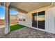 Cozy covered patio featuring paved flooring, complemented by a sliding glass door and adjacent grass patch at 8786 Sand Verbena Ave, Las Vegas, NV 89117