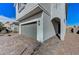 Angle view of a gray home showing the two-car garage, paver driveway and an arched entryway at 8786 Sand Verbena Ave, Las Vegas, NV 89117