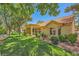 Well-maintained backyard with mature trees, lush lawn, and covered patio extending from the house at 9024 Starmount Dr, Las Vegas, NV 89134