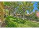 Manicured backyard featuring lush green lawn, mature trees, and manicured hedges at 9024 Starmount Dr, Las Vegas, NV 89134