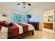 This sunlit bedroom includes access to an ensuite bathroom and a large window with a wood dresser at 9024 Starmount Dr, Las Vegas, NV 89134