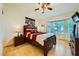 Comfortable bedroom with a bay window, ceiling fan, and wood floors, offering a bright and inviting space at 9024 Starmount Dr, Las Vegas, NV 89134
