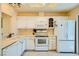 Bright kitchen featuring white cabinetry, tile floors, and modern appliances, including a built-in microwave and refrigerator at 9024 Starmount Dr, Las Vegas, NV 89134