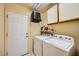 Functional laundry room featuring a washer, dryer, cabinets, and convenient storage solutions at 9024 Starmount Dr, Las Vegas, NV 89134