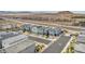 An aerial view captures modern homes in a planned community near desert hills and a highway at 9876 Magnus Ct, Las Vegas, NV 89178