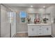Modern bathroom with granite counters, double sinks, and a walk-in shower with white subway tile at 9876 Magnus Ct, Las Vegas, NV 89178