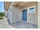 Charming home entrance with a blue front door, gray exterior, and paved walkway leading to the entrance at 9876 Magnus Ct, Las Vegas, NV 89178