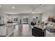 Spacious living room featuring tiled floors, modern furniture, and an open layout to the kitchen at 9876 Magnus Ct, Las Vegas, NV 89178