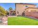 Landscaped backyard with synthetic grass and a covered patio at 10212 Cider Mill Rd, Las Vegas, NV 89135