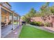 Landscaped backyard with covered patio and synthetic grass at 10212 Cider Mill Rd, Las Vegas, NV 89135