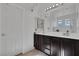 Bathroom featuring a double sink vanity, bright lighting, and a large mirror at 10212 Cider Mill Rd, Las Vegas, NV 89135